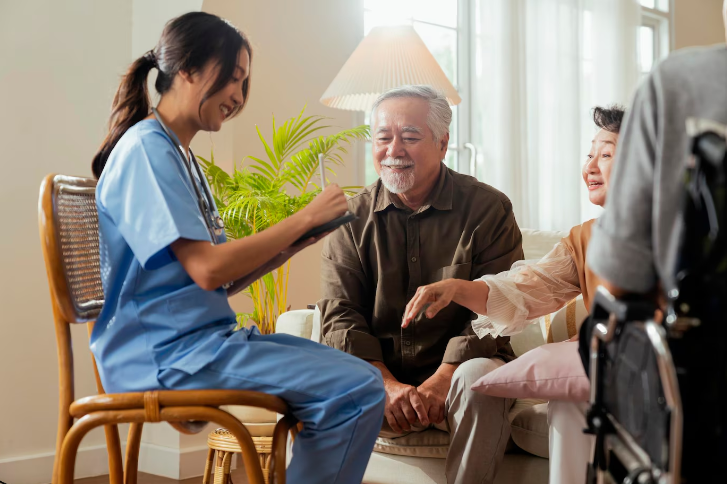 Nurse helping a patient sit up in bed with a warm smile.