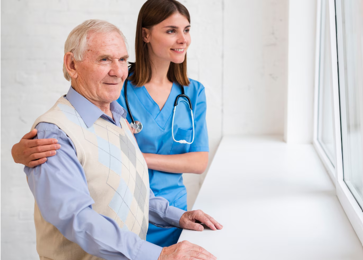 Nursing taking care of old man with smile near window