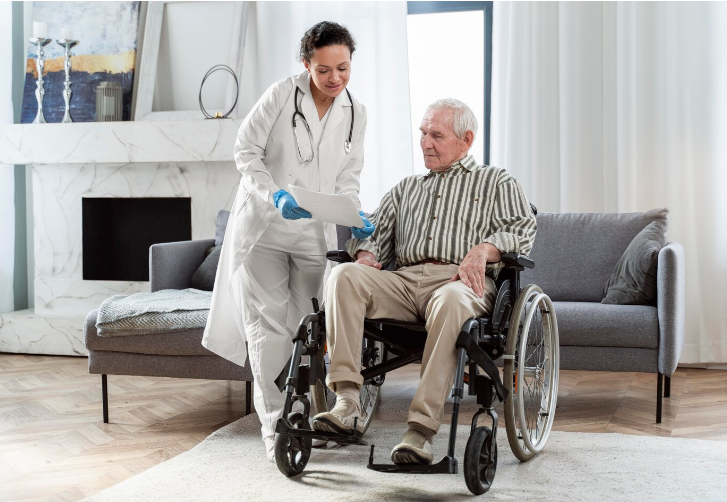 Healthcare worker assisting a patient in a wheelchair down a hallway